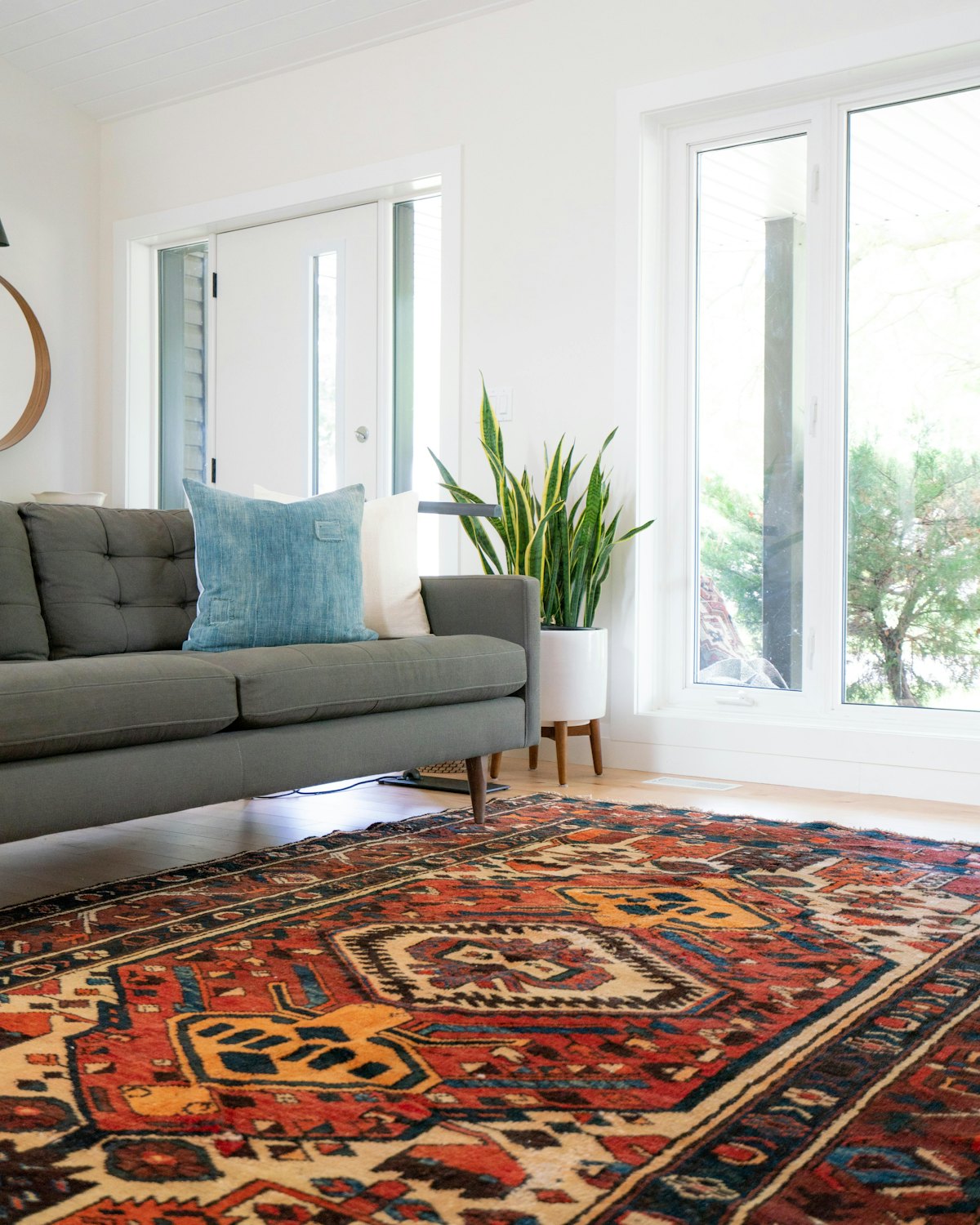 Teal two-seat couch on a red area rug