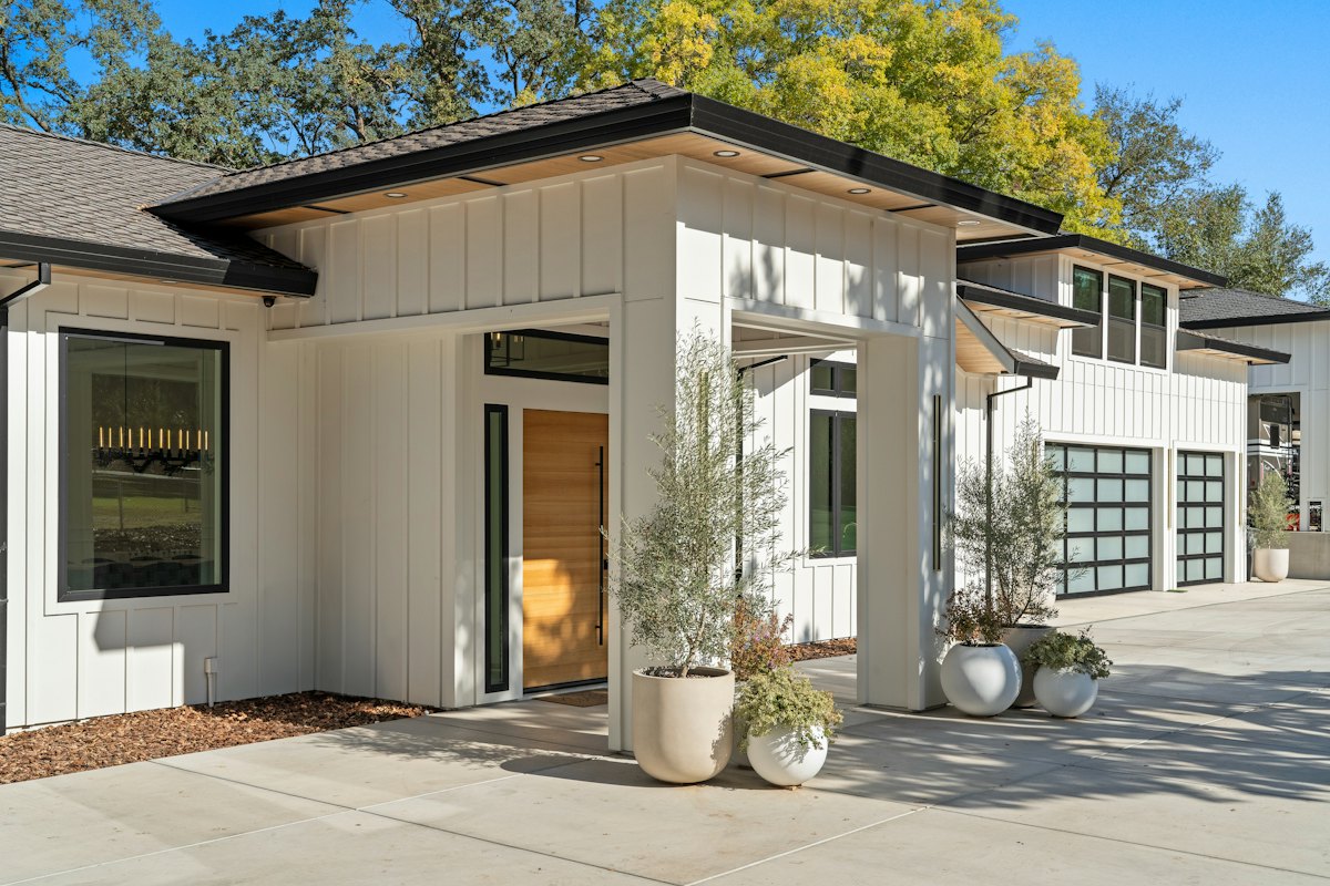 Modern home with a smooth concrete driveway and glass garage doors